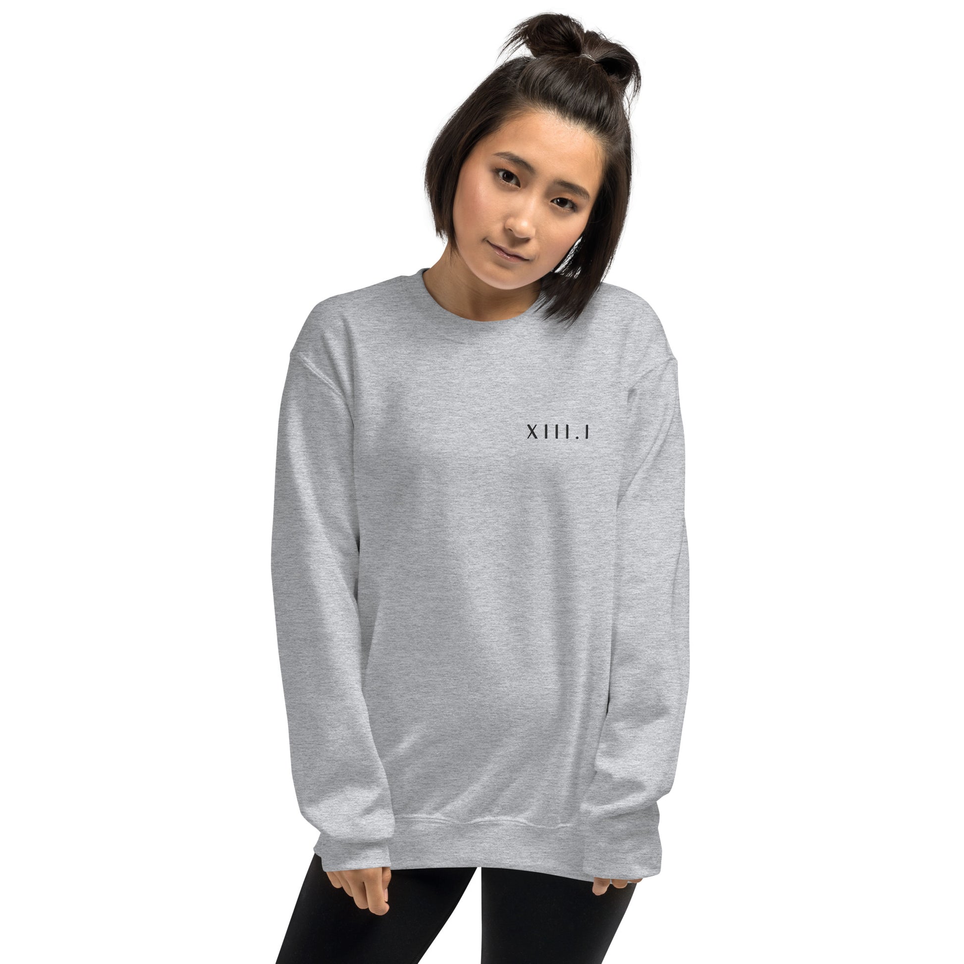 woman wearing a light grey unisex sweatshirt with XIII.I 13.1 half marathon in roman numerals embroidered in black writing
