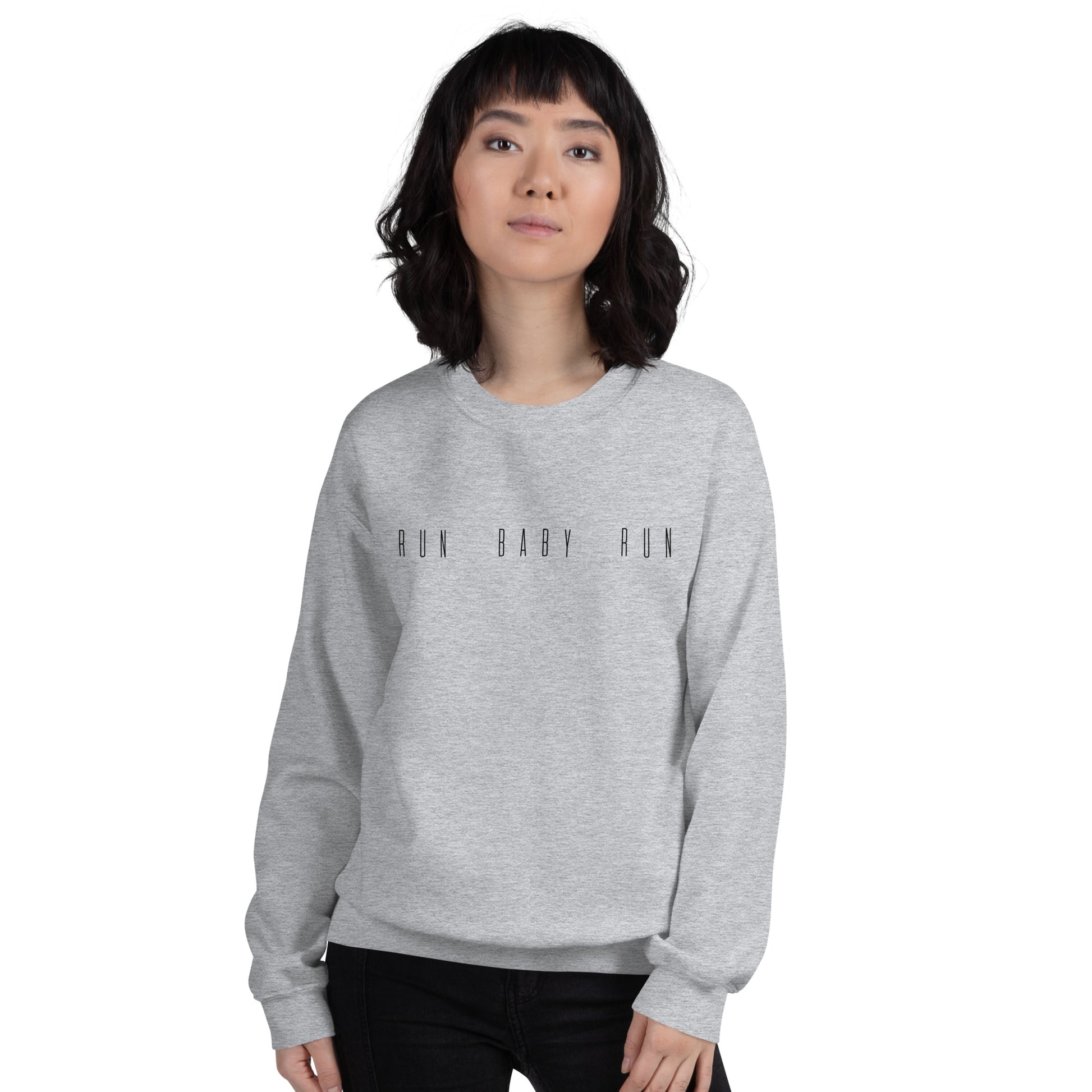 woman wearing a grey sweatshirt with the words run baby run across the chest