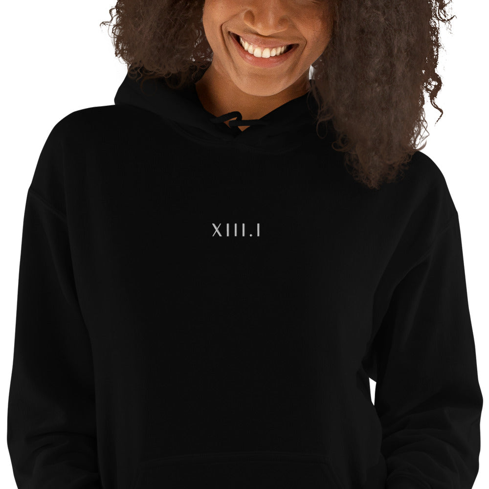 woman wearing a black unisex hoodie with XIII.I 13.1 half marathon in roman numerals embroidered in white writing