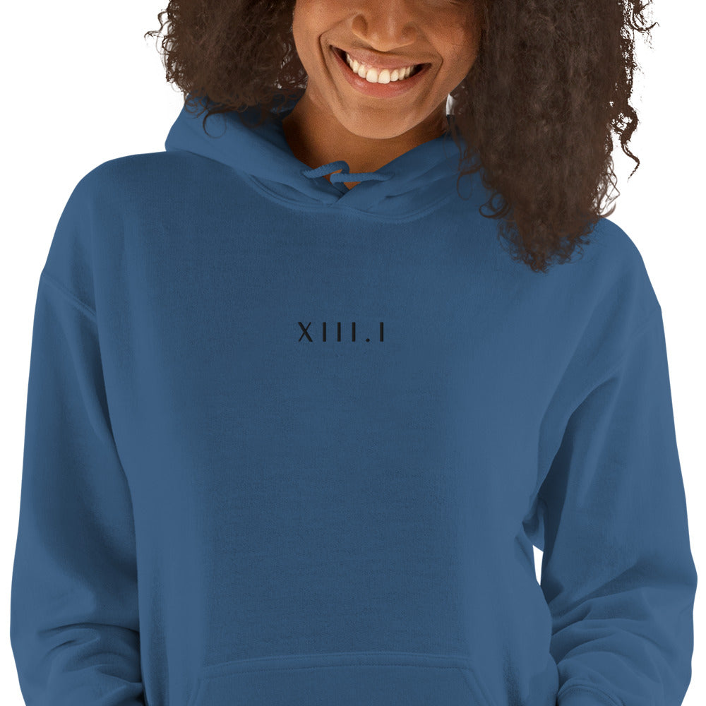 woman wearing a blue  unisex hoodie with XIII.I 13.1 half marathon in roman numerals embroidered in black writing