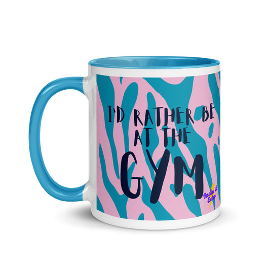 Blue handled mug with I'd rather be at the gym written on it, across a blue and pink animal print background. A gift for someone who loves the gym.