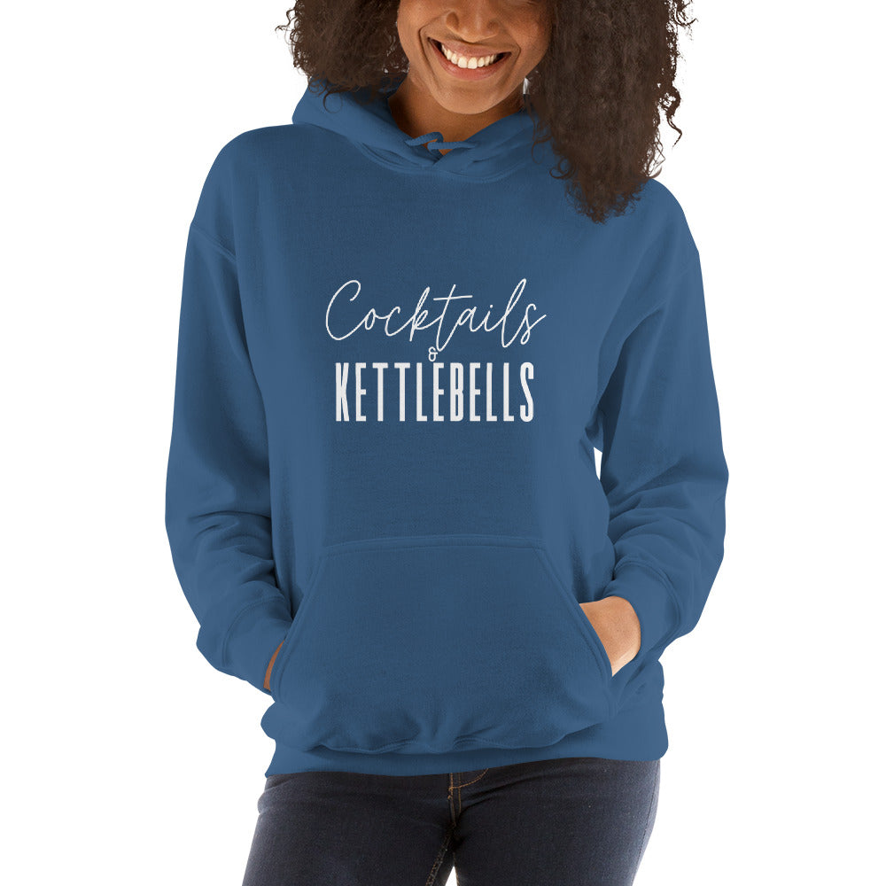 woman wearing a blue hoodie with the words cocktails and kettlebells in a white font across the chest