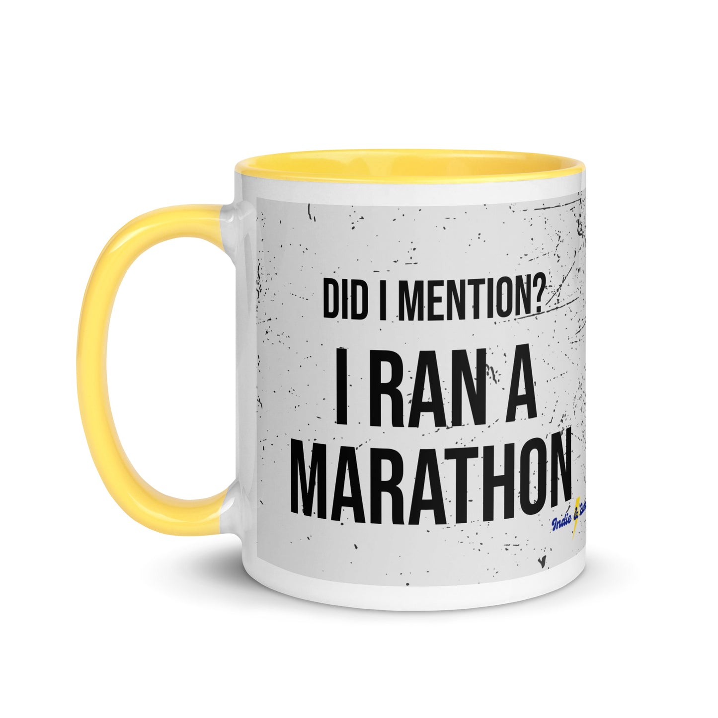 yellow handled mug with an ink splatter design, and the words did i mention? I ran a marathon in a capitalised, bold black font. 